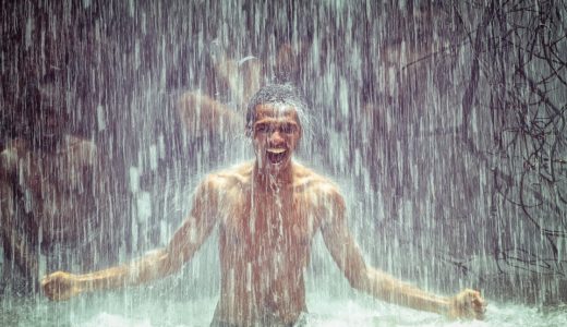 滝つぼで水を浴びる男性